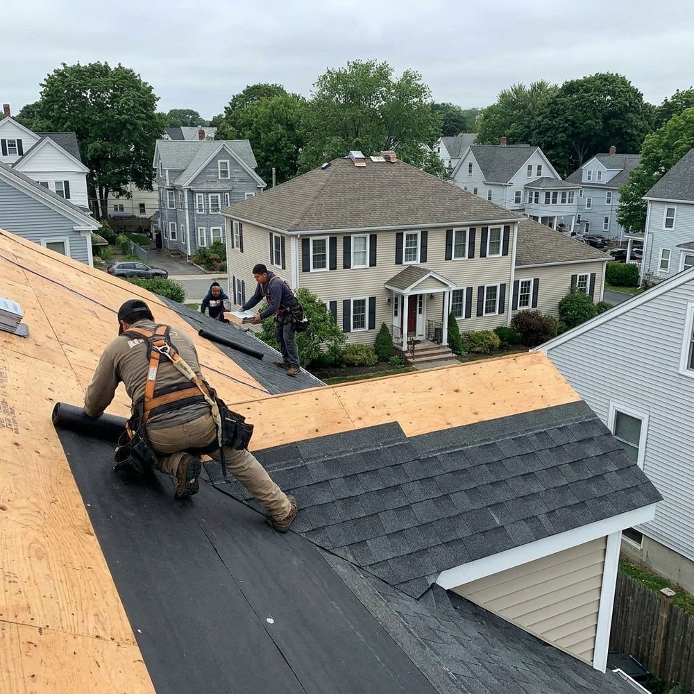 Roof stripped to clean decking with synthetic underlayment down and new charcoal architectural shingle courses going up the slope